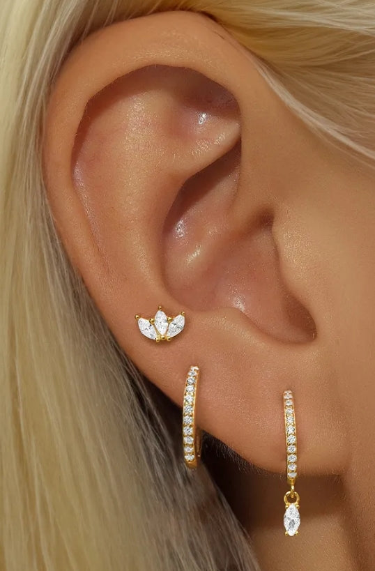 Gold earrings set with lotus stud and zirconia hoop on model ear